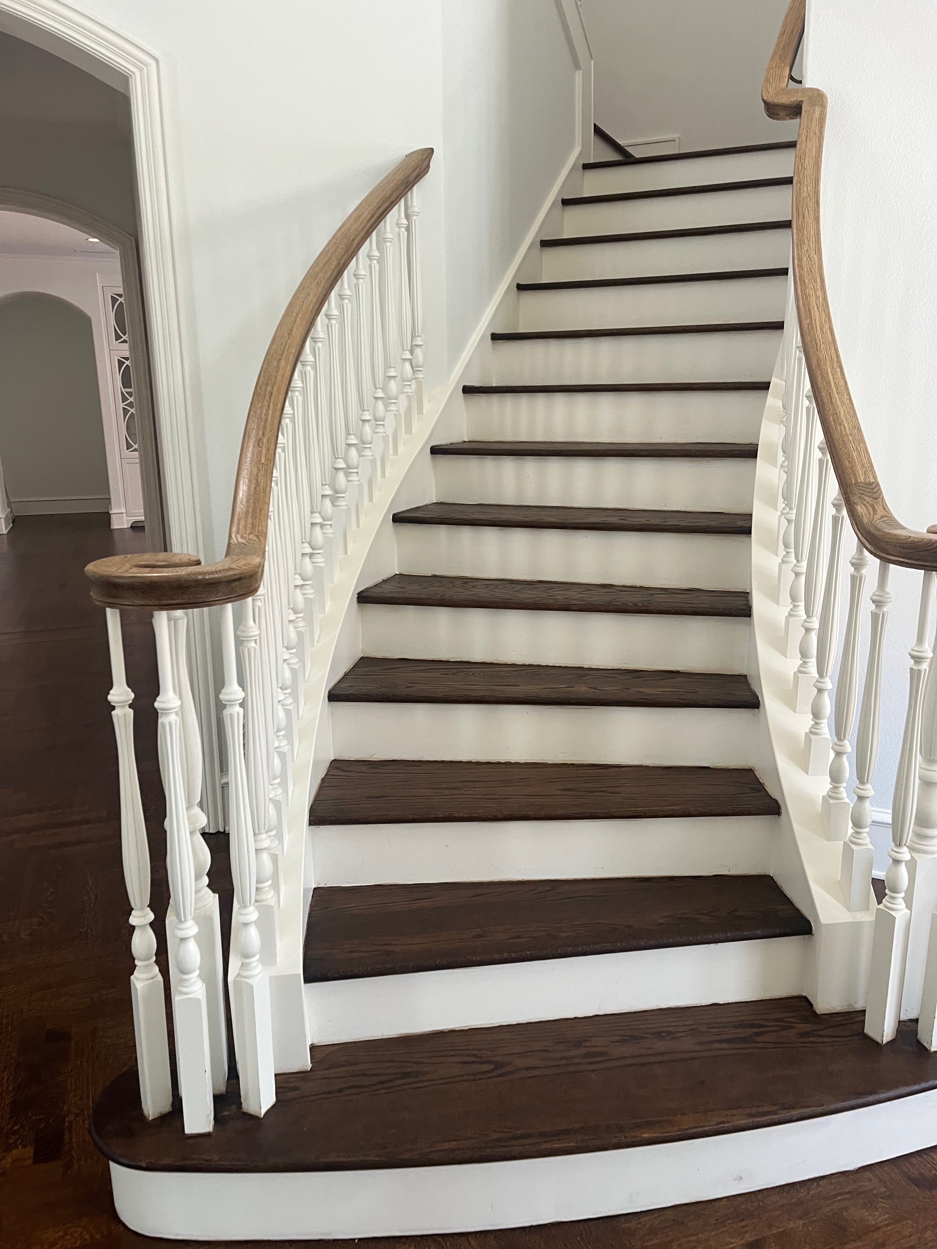 Curved staircase with dark stained hardwood treads