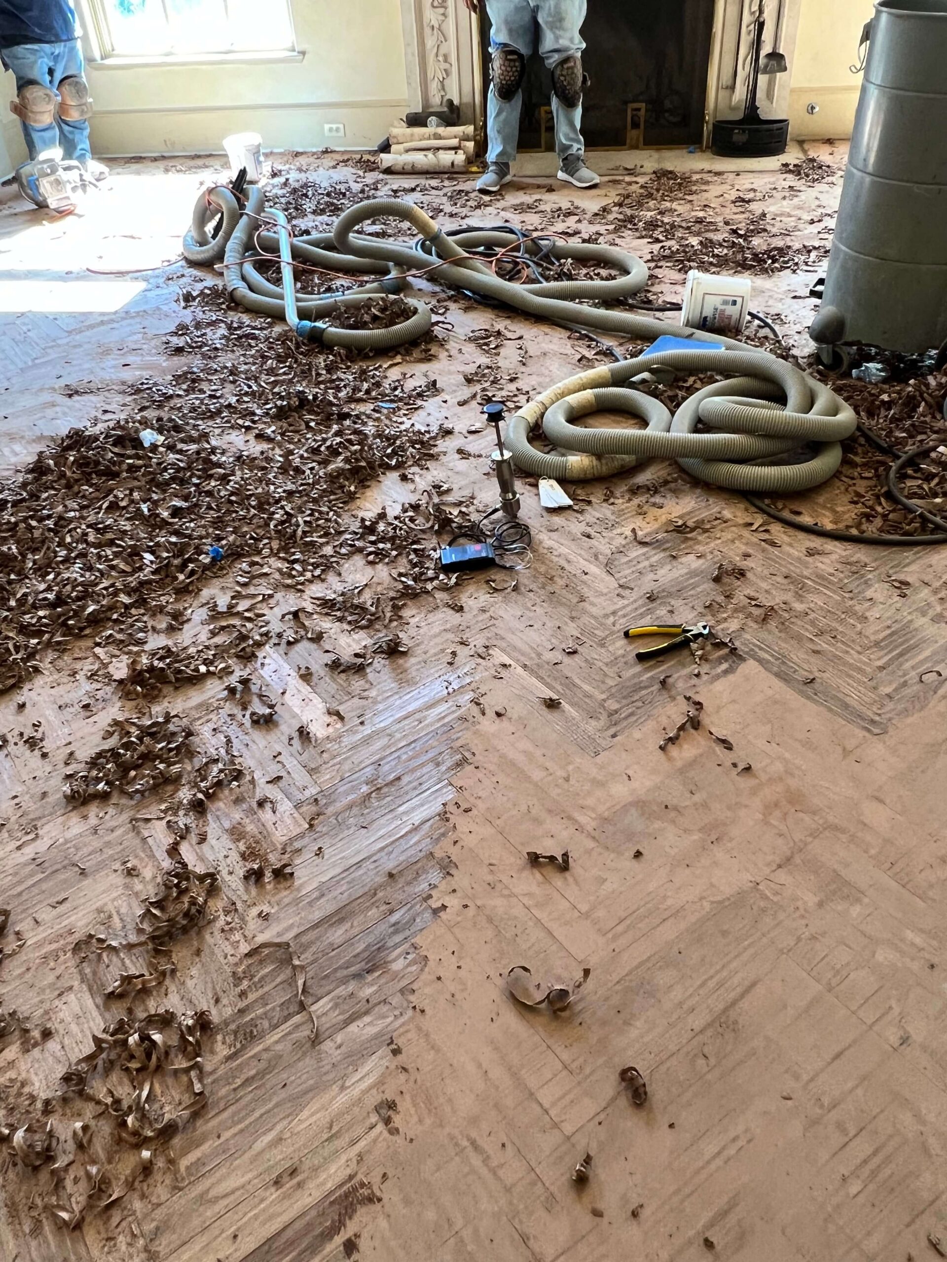 Moisture meter testing hardwood flooring during a custom floor installation